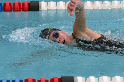 Picture of a young woman swimming freestyle in the pool. Her head is on it's side whilst she takes a breath. Breathing & Swimming: Heighten Awareness