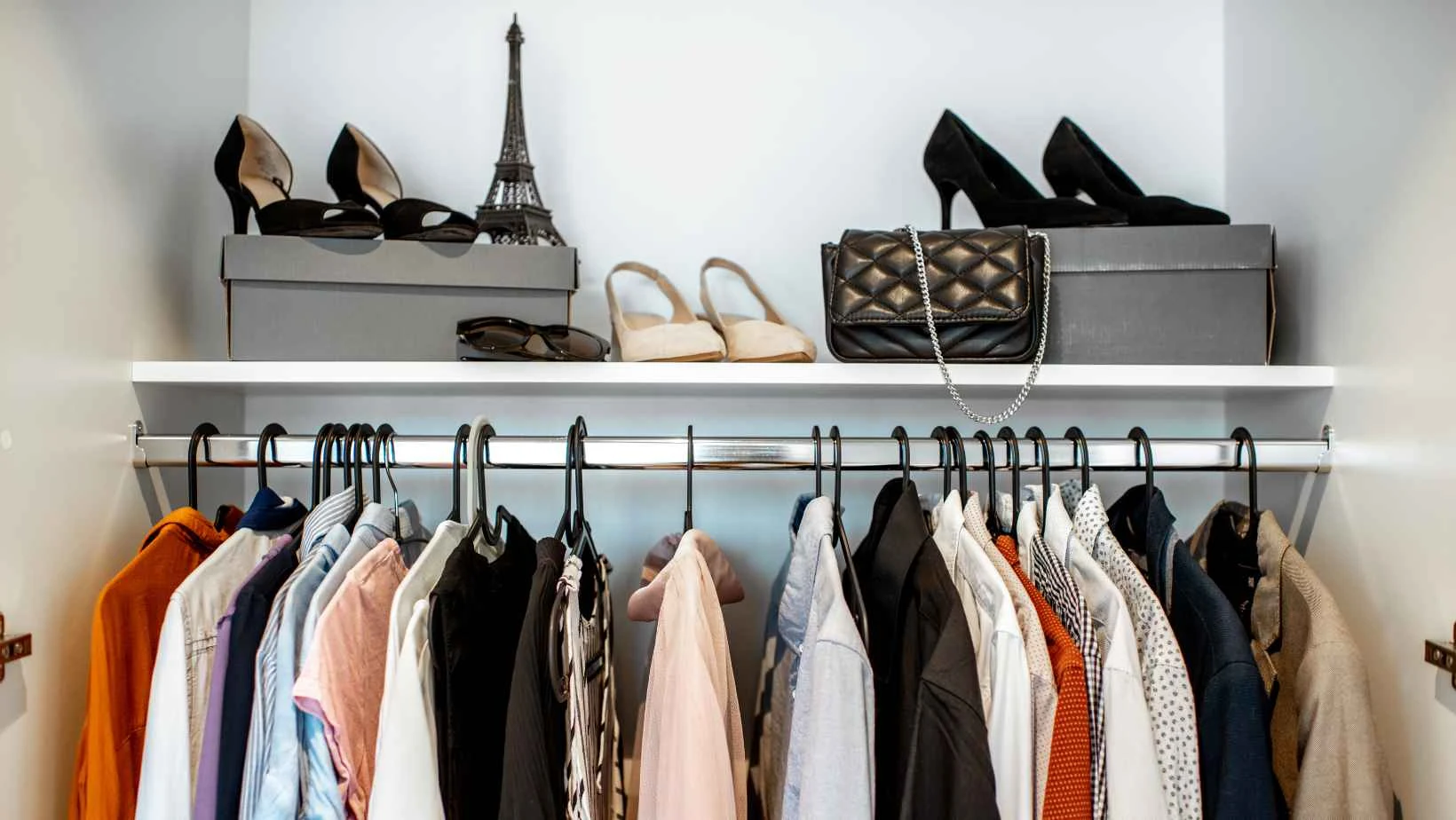 Stock image of clothes hanging in a wardrobe and shoes