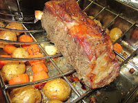 Roasting meats in a pan with vegetables.