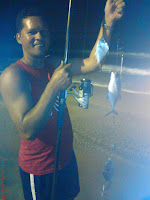 Foto de um pescador com vara e peixes no anzol