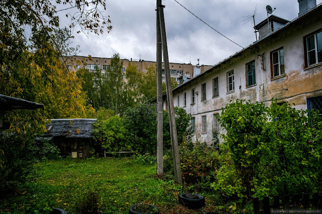 Кустарники и сараи по дворе двухэтажного здания