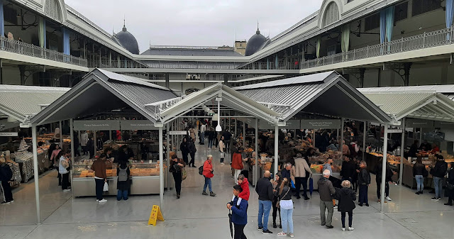 Estrutura interior do Mercado do Bolhão, com s corredores centrais compostos com vendedores e pessoas a circular