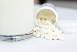 Lactase enzyme tablets and a glass of milk