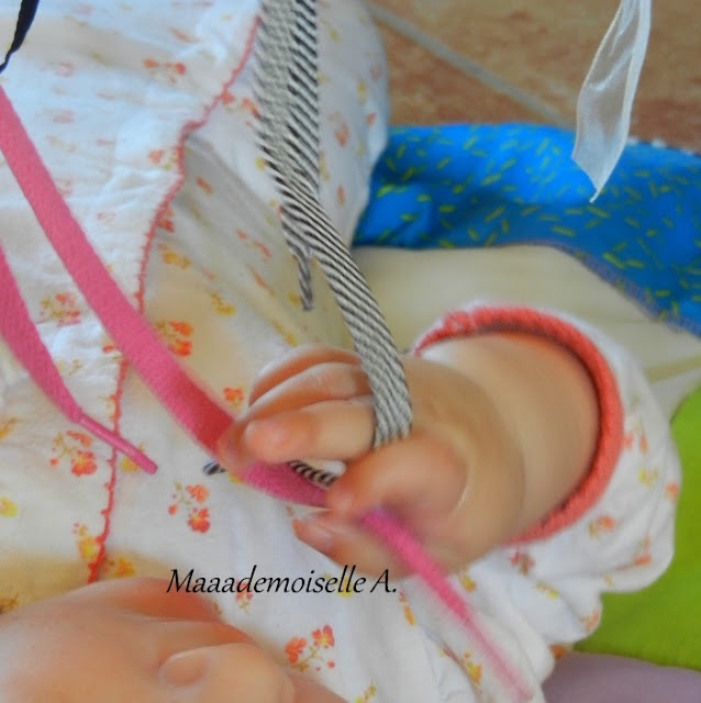 || Lacets, cordelettes, rubans ; un portique pour bébé gai et coloré