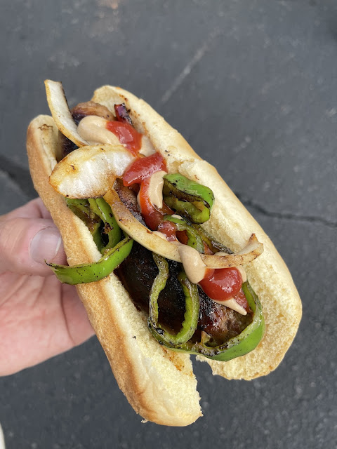 Tailgating sausage with peppers on top.