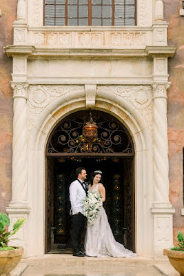 bride and groom posing outside of The Howey Mansion