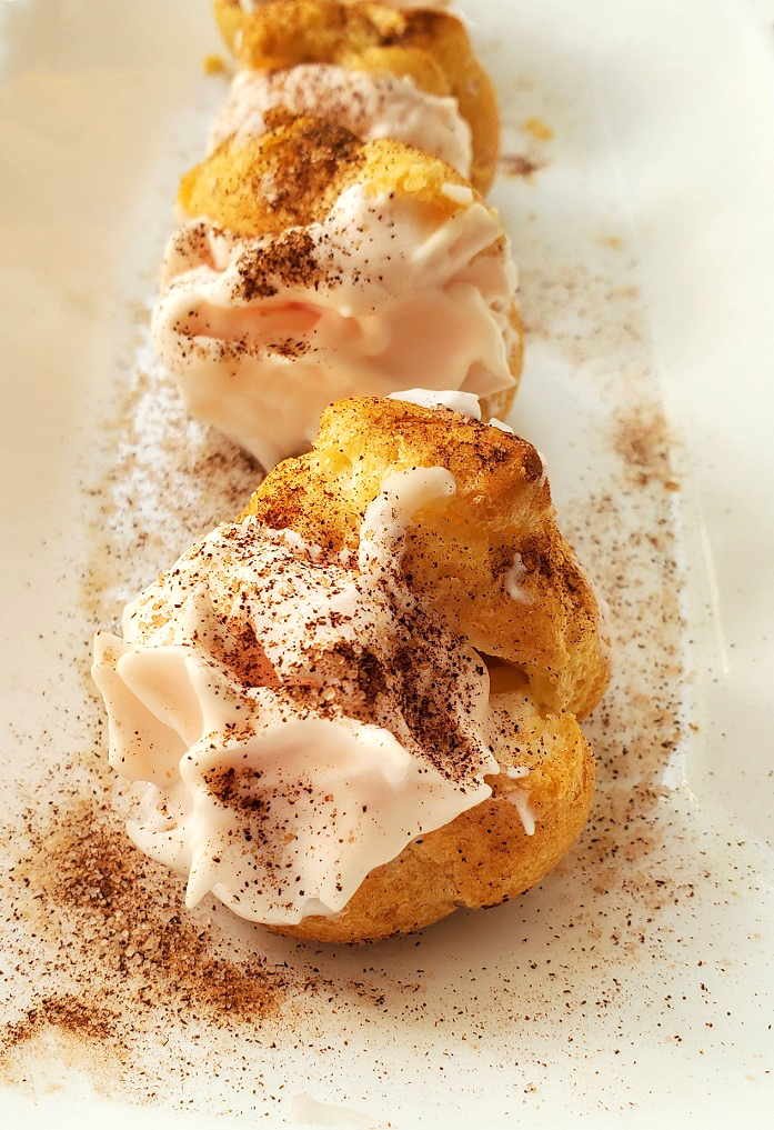 cream puffs filled with pumpkin whipped cream dusted with cinnamon sugar