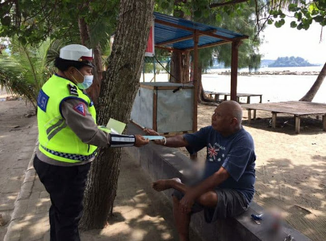 Sat Lantas Polresta Jayapura Edukasi dan Bagikan Masker di Pantai Hamadi