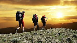 Des randonneurs en montagne à l’approche du coucher du soleil