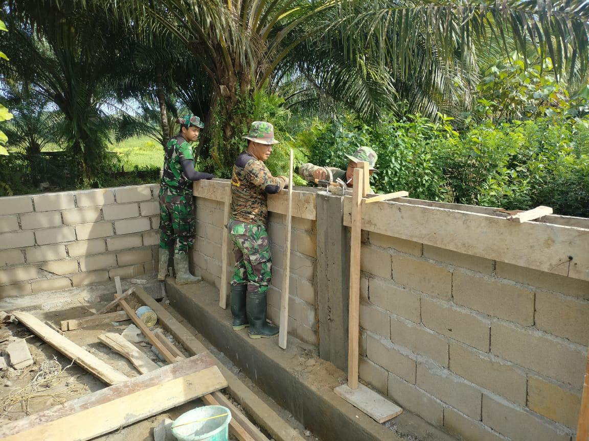 Anggota satgas TMMD lanjutkan pemasangan Batako pagar Pustu bersama masyarakat.