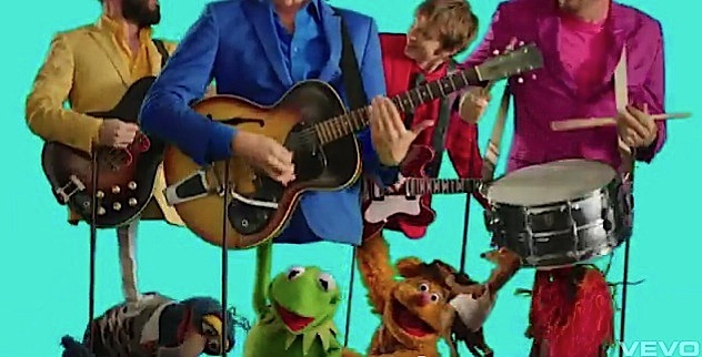 Torsos of the OK Go quartet with Muppets Animal, Fozzie Bear, Kermit the Frog, and Gonzo beneath them as if puppeteering