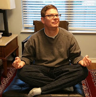 David Borden sitting in a very bad Buddha pose.