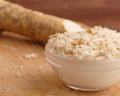 A bowl of grated horseradish in front of a horseradish root ♥ KitchenParade.com.
