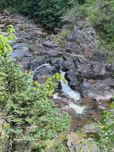 A waterfall emerges from the jumbled rocky landscape of Lester Park.
