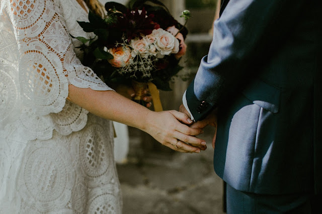 bride and grooms hands holding romantic bouquet