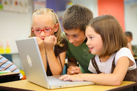 Tres niños haciendo uso del ordenador