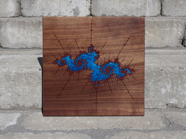 Julia set fractal made of multiple layes of epoxy resin on walnut wood