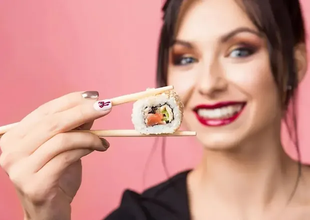 A white woman eating sushi platter