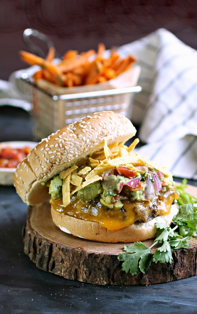 Recipe for a burger with southwestern flavors and topped with guacamole and crunchy tortilla strips.