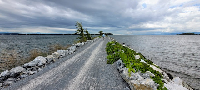 Man biking on causeway in Lake Champlain.