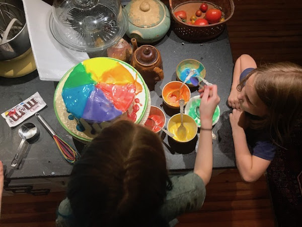 girls decorating a cake, view from above