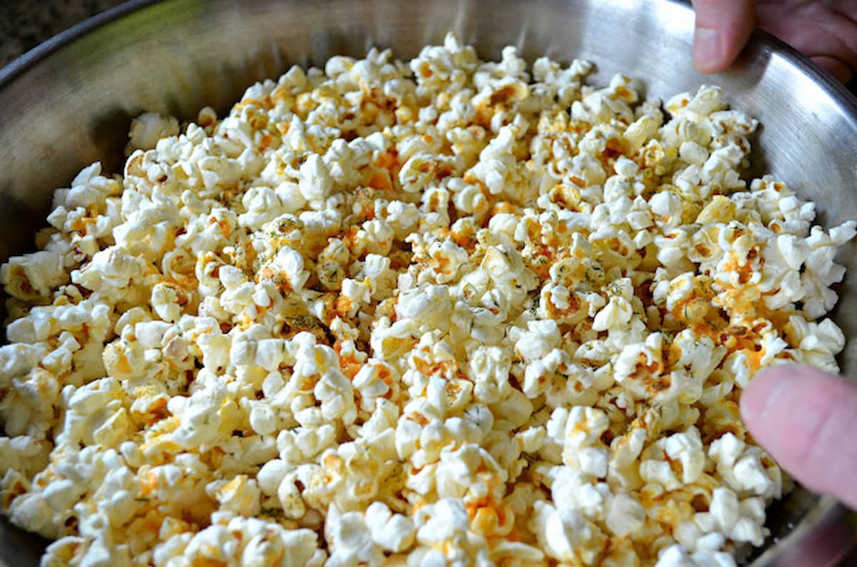 A large stainless steel bowl of Buffalo Ranch Popcorn from scratch.