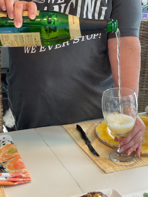 A tall stream of cider being poured into a glass.