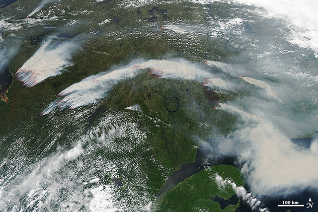 On 4 July 2013, the Moderate Resolution Imaging Spectroradiometer (MODIS) on NASA's Aqua satellite captured this image of wildfires burning in western Quebec near James Bay. Red outlines indicate hot spots where MODIS detected unusually warm surface temperatures associated with fire. Photo: NASA