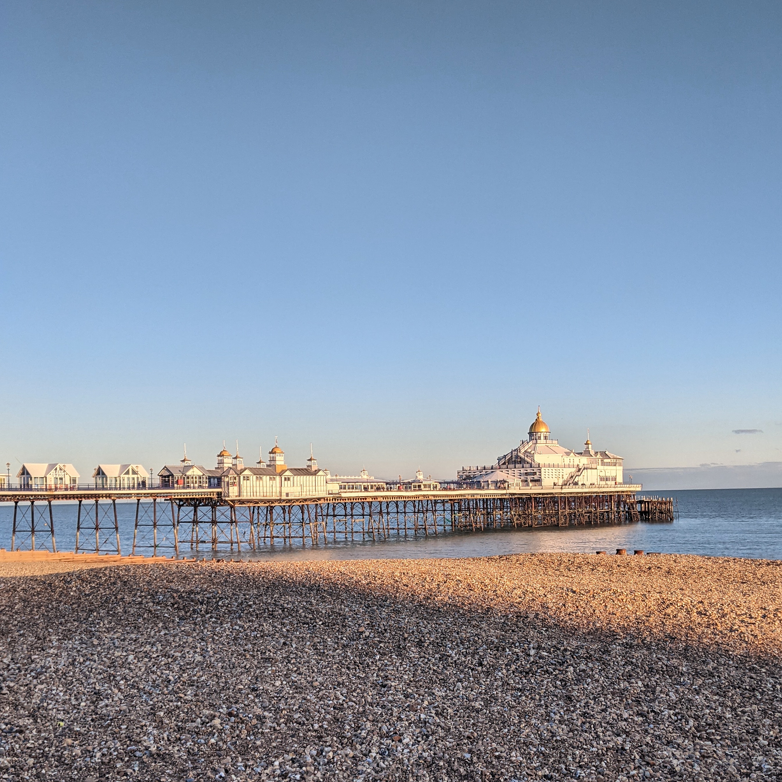 the pier at eastbourne dappled in afternoon sunlight