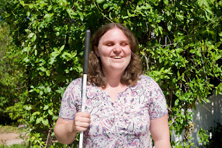 Holly Scott-Gardner standing in the CCB garden with her cane 