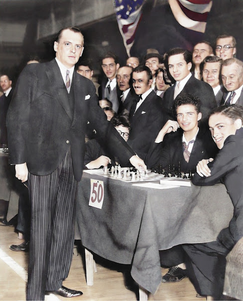 The Russian chess master Alexander Alekhine (1892-1946) came to New York City, New York, United States of America to play simultaneous chess matches with 200 opponents. in this photo he is about to make a move at table number 50.
