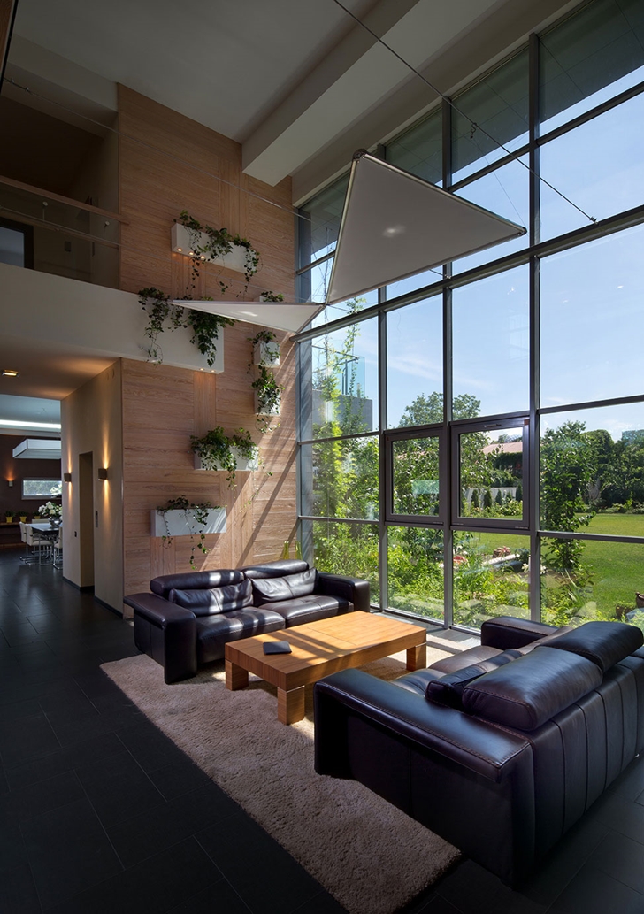 Black leather sofas by the glass wall in Modern house by Yakusha Design