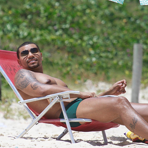 Naldo Benny apenas de cueca deitado em cadeira de praia mostrando corpo sarado