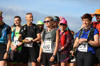 Me with an expressionless face standing with other runners at the start line.