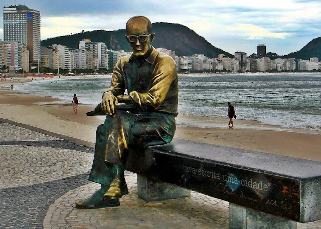 Estátua em homenagem à Carlos Drummond de Andrade no calçadão da praia de Copacabana, Rio de Janeiro (reprodução internet)