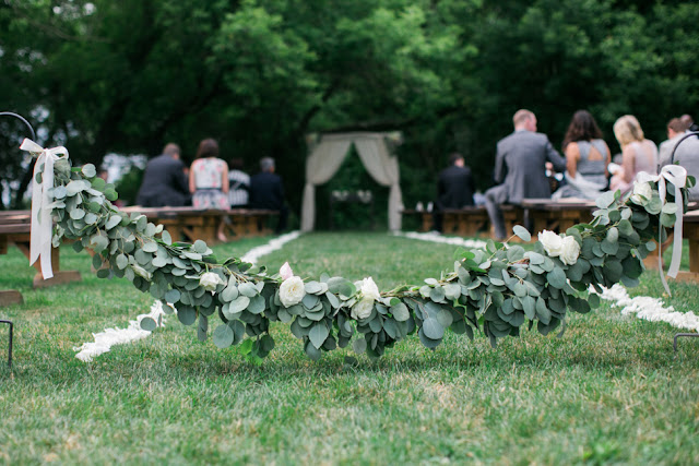 Silver dollar eucalyptus and roses garland aisle decor barn wedding ann arbor A second garland was used to block of the main Aisle which was lined with white rose petals on either side.  We used shepherds hoods to suspend the garland and finished it with cascading ribbon. 