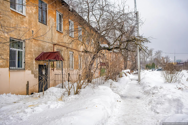 Заснеженная тропа вдоль жилых зданий