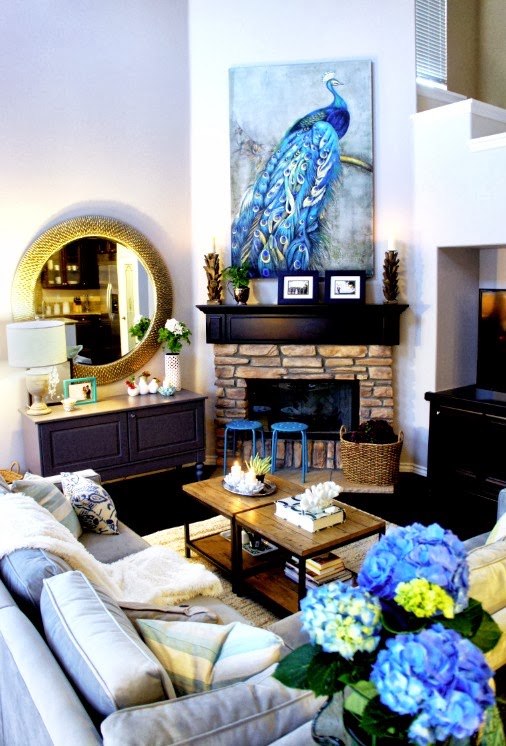 closer look to the living room area shows a cool blue peacock above exposed brick fireplace