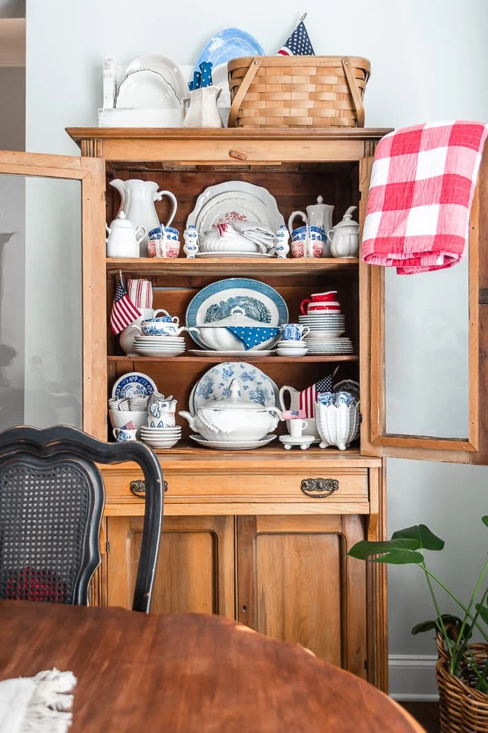 pine hutch with vintage ironstone platters, pitchers, dishes in red white and blue