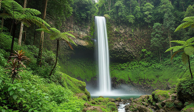 Pemandangan air terjun dengan tebing hijau yang menjulang