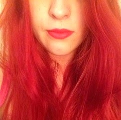 Red head wearing Nars Lipstick in the red shade Heatwave