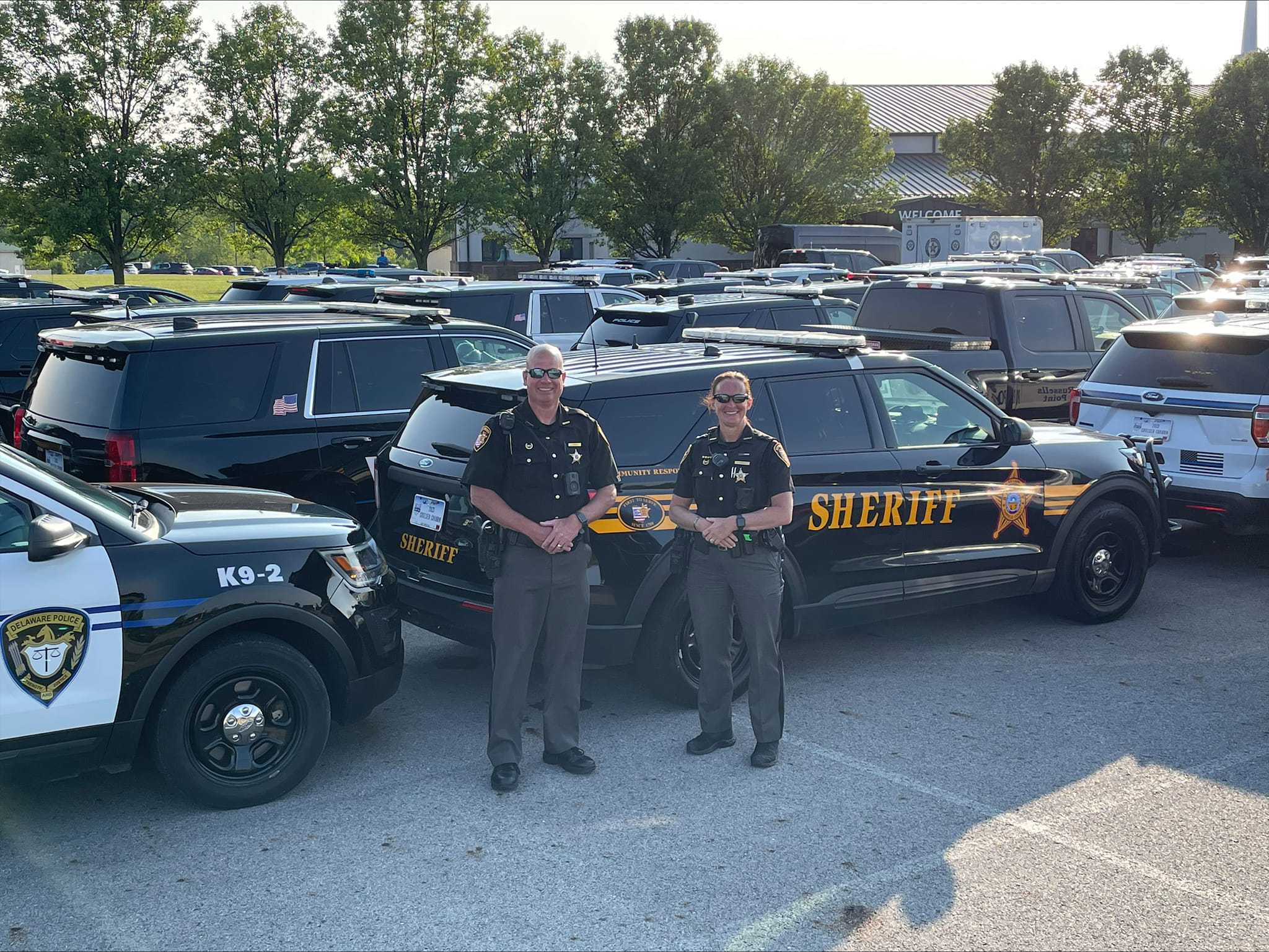 two deputy's standing next to their vehicles