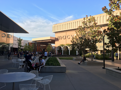 View of Stanford Shopping Center in Palo Alto, California, featuring landscaped walkways and upscale storefronts in an open-air setting.