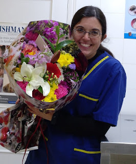 Mi foto vestida de veterinaria con un gran ramo de flores en la mano