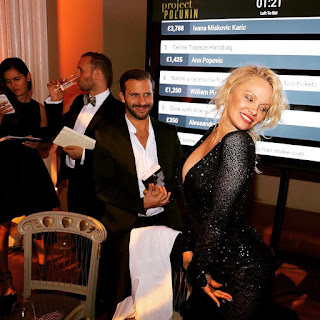 Actress Pamela Anderson dancing for Lukas Kroulik to be photographed in her traditional sexy manner