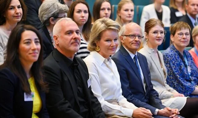 Queen Mathilde wore a camel ruffled skirt and white silk shirt from Natan. Christine Bekaert gold earrings. Junior board day