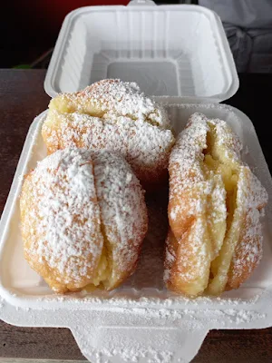 " Creamy pudding filled doughnuts with powdered sugar"