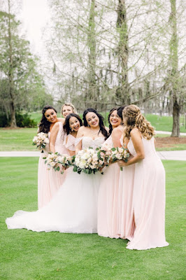 bride and bridesmaids in pink dresses smiling