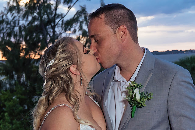 Bride and Groom kissing with the sunsetting