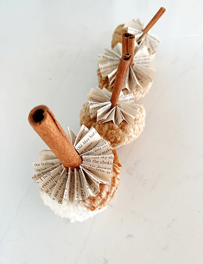 sherpa ornaments with book page bottoms and cinnamon stems